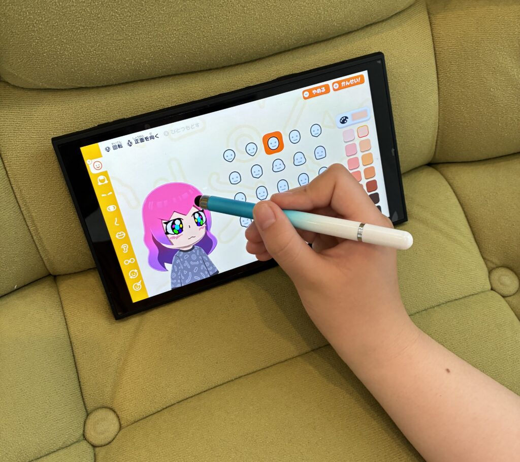 Nintendo Switch2でトモダチコレクションを遊び、タッチペンでフェイスペイントをしている様子。