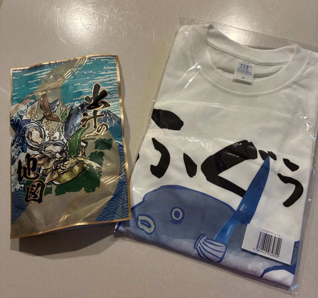 うお一番で購入したお土産の出汁の地図(出汁パック)とふぐぅTシャツ。